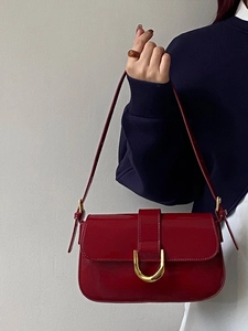 Vue détaillée de la texture en cuir verni rouge brillant et de la boucle en métal doré