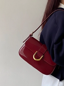 Vue détaillée du sac à bandoulière bordeaux verni avec boucle en fer à cheval dorée