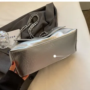 Detailed base view of silver metallic chain bag showing smooth rectangular bottom and texture