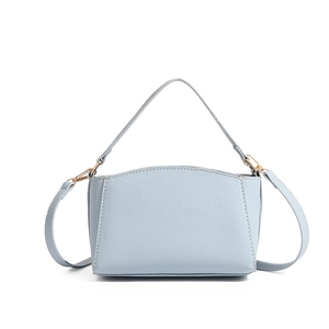 Close-up of light blue lychee pattern leather bag with golden metal buckle and strap