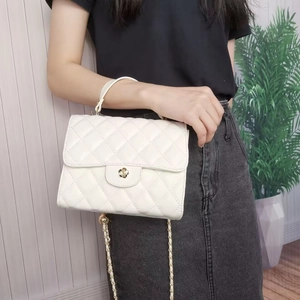 Dettaglio di una borsa trapuntata bianca con chiusura a scatto dorata a forma di fiore