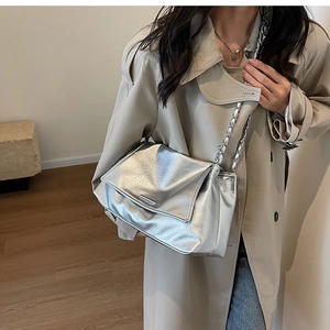 Detail showing the silver metallic wrinkled leather texture and silver chain strap on the bag