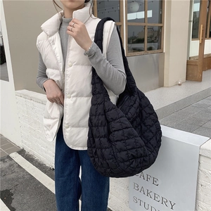 Close-up of quilted texture and soft padded detail on the black cloud shoulder bag