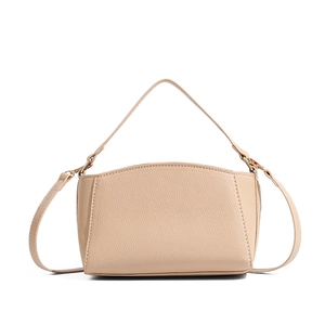 Close-up of beige lychee pattern leather handbag with elegant pale gold hardware details