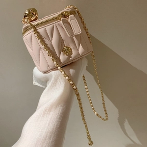 Pink quilted mini box bag with gold flower clasp and metal chain strap for women