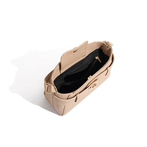 Interior view of khaki textured shoulder bag with black lining and golden magnetic clasp
