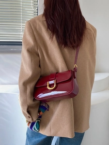 Sac bandoulière chic en cuir verni bordeaux avec boucle fer à cheval dorée et brillant