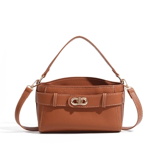 Close-up of brown lychee grain leather with white stitching and gold interlocking clasp