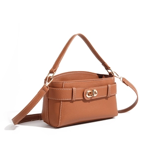 Detail of caramel lychee leather Kelly bag with white stitching and gold twist lock