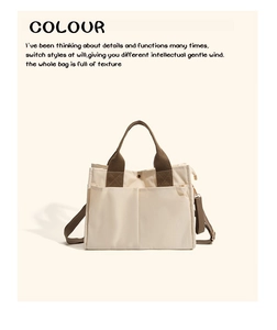 Detail of cream canvas mommy bag showing front pockets and olive green handles