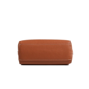 Macro detail of brown pebble leather bag base with contrast stitching and fine grain