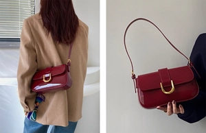 Gros plan du sac à bandoulière en cuir verni bordeaux avec boucle fer à cheval dorée