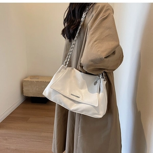 Close-up of soft white leather tote bag with silver chain strap and metal trim details
