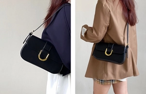 Vue détaillée du sac sous le bras minimaliste noir avec boucle fer à cheval dorée