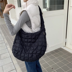 Detailed close-up of a black quilted cloud bag showing the soft texture and gold zipper