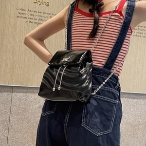 Sac à dos en cuir verni noir avec chaîne argentée et nœud en cristal étincelant