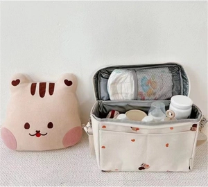 Internal view of bear pattern diaper bag with mesh pocket and baby feeding supplies