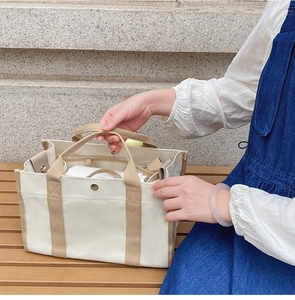 Dettaglio interno della borsa in tela color crema con vari scomparti organizzativi