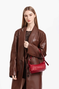 Detail der roten Leder-Hobo-Tasche mit Silberschnalle und braunem Ledermantel