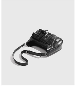 Detailansicht der schwarzen Glanzleder-Tasche mit Utility-Taschen und Punk-Metallketten