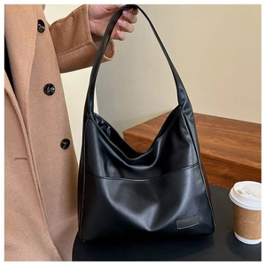 Detail of soft black faux leather texture on large capacity tote bag for daily commute