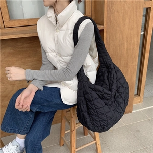 Detailed view of the black quilted hobo bag's soft texture and wide shoulder strap