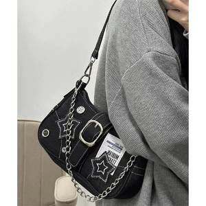 Detail view of black denim Y2K star crossbody bag with metal chains and silver studs