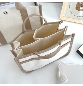 Vista dettagliata della borsa in tela beige con tre scomparti interni multifunzionali