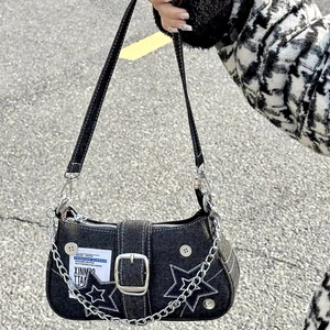 Detail view of denim star underarm bag with white stitching and silver metal chain