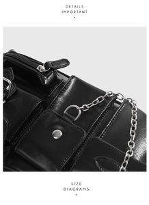 Detailansicht der schwarzen Lackledertasche mit Schnallen, Reißverschlüssen und Metallkette