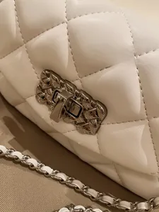 Macro shot of white quilted leather texture and silver textured metal clasp detail
