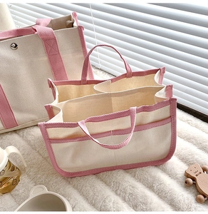 Dettaglio della borsa fasciatoio in tela con bordo rosa e scomparti interni multipli