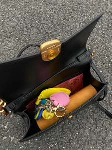 Dettaglio dell'interno della borsa in pelle nera con scomparto principale e tasca con cerniera