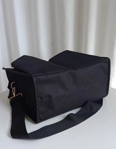 Close-up of black nylon diaper bag with reinforced wide strap and gold hardware