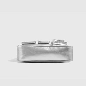Detailansicht der silbernen Metallic-Tasche mit strukturierter Oberfläche und Taschen