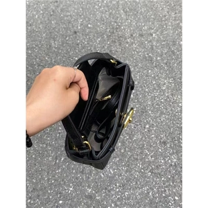 Black litchi grain leather handbag with gold hardware and spacious interior compartments