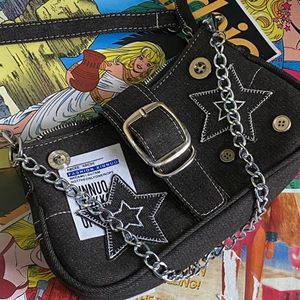 Detailed view of black denim star shoulder bag with silver chains and Y2K star patches