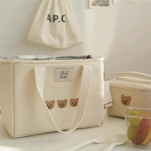 Close-up of insulated inner foil and cute bear embroidery on beige canvas lunch bag