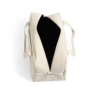 Top view of open off-white canvas diaper bag with black lining and metal D-ring details