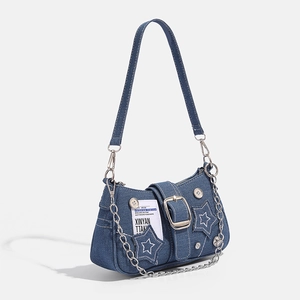 Detail view of denim star shoulder bag featuring metallic chains and retro label