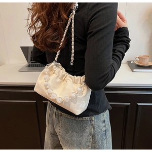 Detail der cremeweißen Cloud Bag mit großen transparenten Perlen und Kettenriemen
