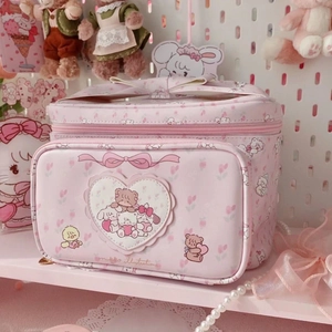 Detail of pink Mikko cartoon cosmetic bag featuring heart patch and bow handle