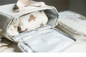 Detail of insulated diaper bag with silver thermal lining and cute bear embroidery