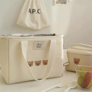 Detail of insulated lunch bag featuring bear embroidery and thermal foil lining