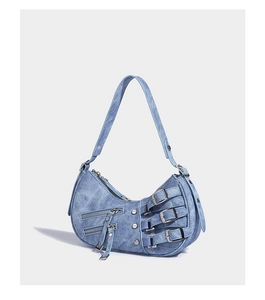 Detail of light blue denim crescent shoulder bag with silver buckles and punk studs