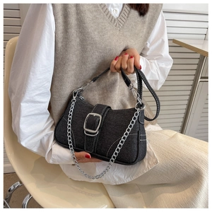Dettaglio della borsa a spalla in denim blu scuro con fibbia argento e cuciture bianche