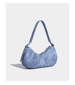 Detail of light blue washed denim hobo bag with zipper closure and adjustable metal buckle