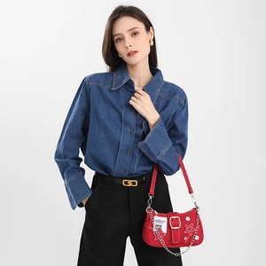 Star-patterned red denim underarm bag with chain detail shown on a model outfit
