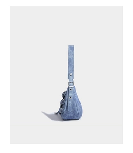 Detail view of denim shoulder bag featuring silver buckle straps and retro aesthetic
