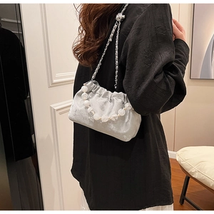 Detail der silbernen Cloud-Bag mit großem Perlengriff und eleganter Metall-Kettenriemen
